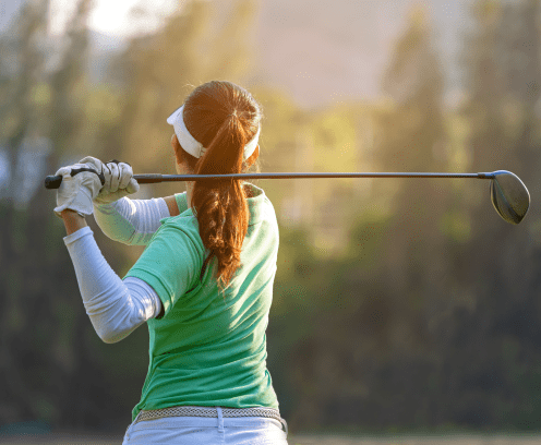 Sport Healthy. Asian sporty woman golf player doing golf swing tee off on the green sunset evening time, she presumably does exercise. Healthy and Lifestyle Concept.