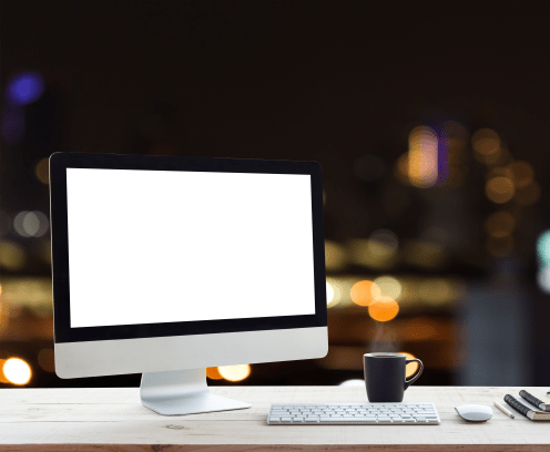 desktop computer on work table and city night background