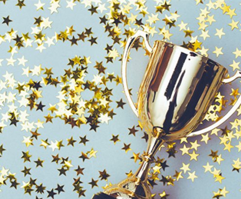 Trophy surrounded by gold stars on a light blue background