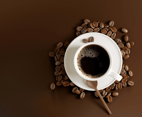 white coffee cup on brown background with coffee beans