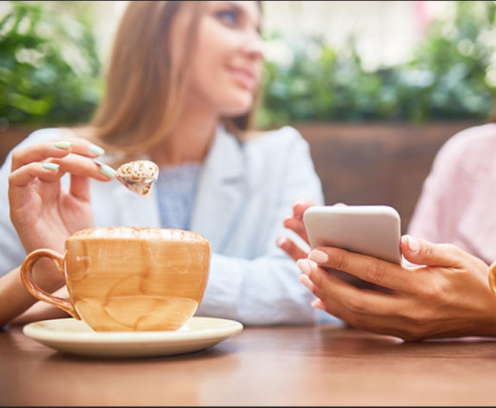 ladies-looking-at-phone-drinking-coffee