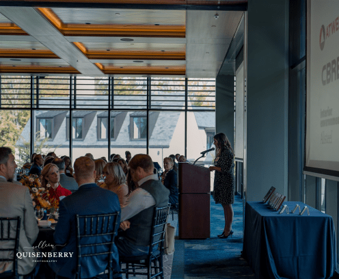 impact award speaker presenting to a seated crowd