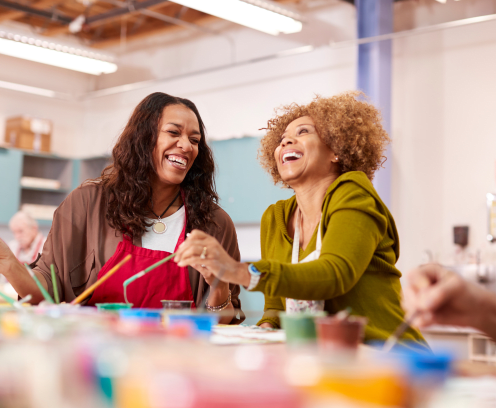 Two Mature Women Attending Art Class In Community Centre Together