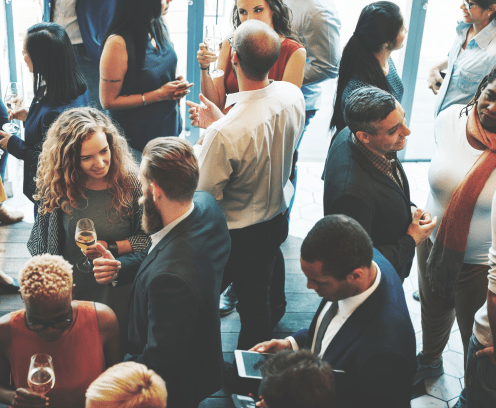 group standing, socializing, some holding wine glasses