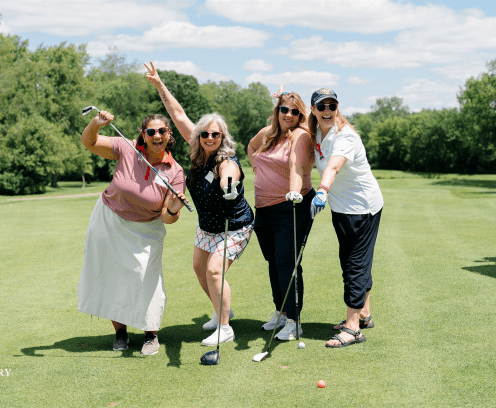Four women golfing.
