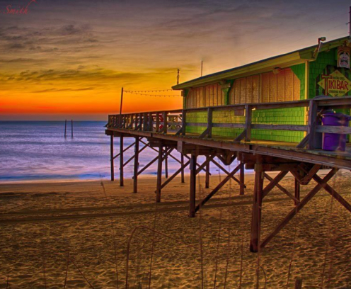 tiki bar at sunset overlooking ocean