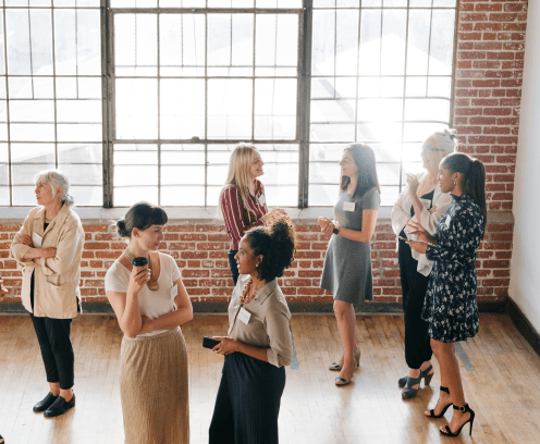 women in front of brick wall with windows