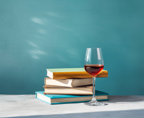 stack-of-book-with-wine-glass-blue-background