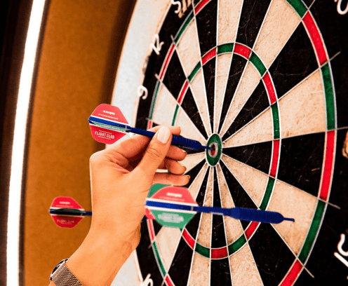 Dart board at Flight Club with three darts.