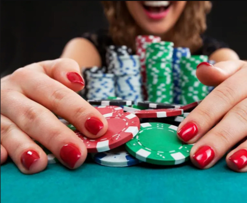 Women raking in poker chips.
