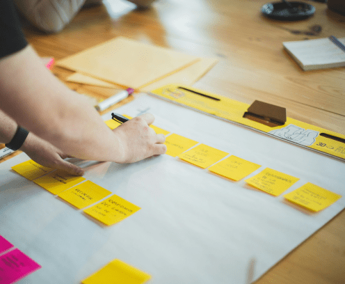 guy-placing-sticky-notes-on-idea-board