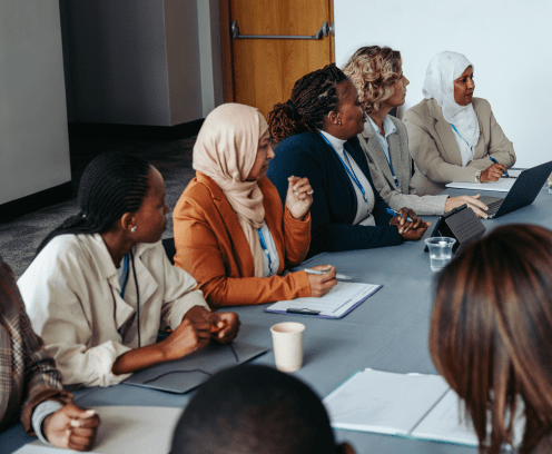 A multiethnic team engaged in a collaborative meeting workshop, focusing on discussion and teamwork. Diverse professionals working together around a conference table.