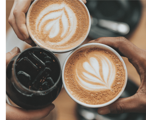 coffee cups held together in a toast by three people