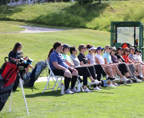 ladies sitting in chairs at a golf clinic