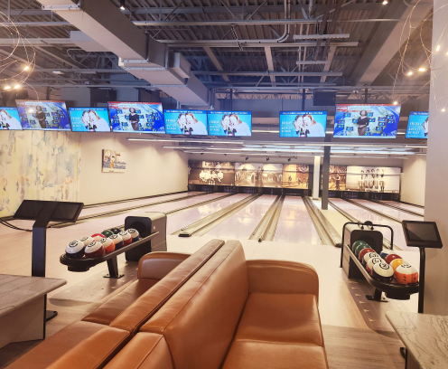 bowling alley with bowling balls and lanes and sreens for scores
