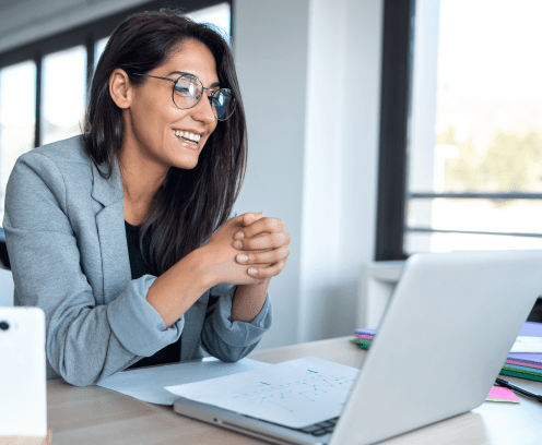 Shot of confident business woman looking and speaking through the webcam while making a video conference with laptop from the office.