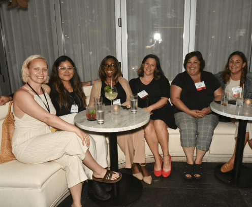 Diverse women sitting on a couch at a cocktail event