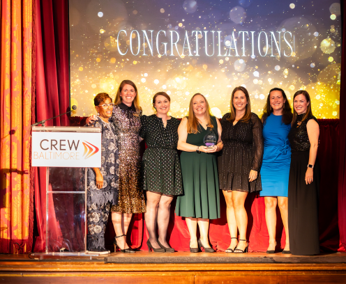 CREWBaltimore Beacon Award Winners smiling and holding awards on a stage
