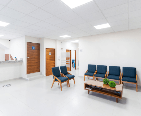 modern medical office with blue chairs and wooden coffee table with marble reception counter