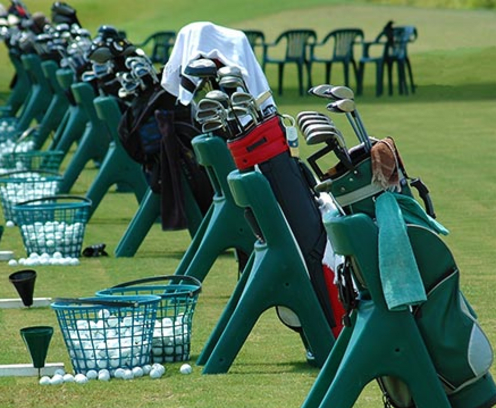 golf-bags-lined-up-with-baskets-of-golf-balls