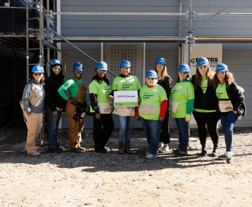 women in green shirts and blue hard hats for the CREW Chicago Women Build Habitat for Humanity event