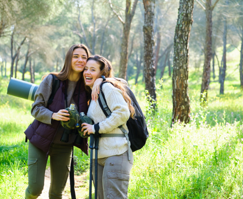 two-women-hugging-and-smiling-on-a-hike