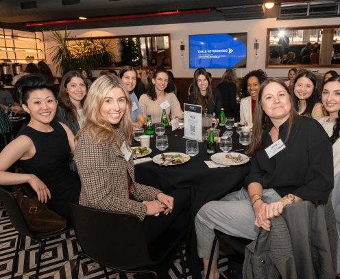 Group of young, diverse female professionals seated at round lunch table at CREWNY program.