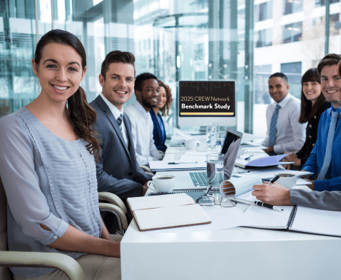 People sitting around a conference table with the 2025 Benchmark Study on the computer screen behind them.