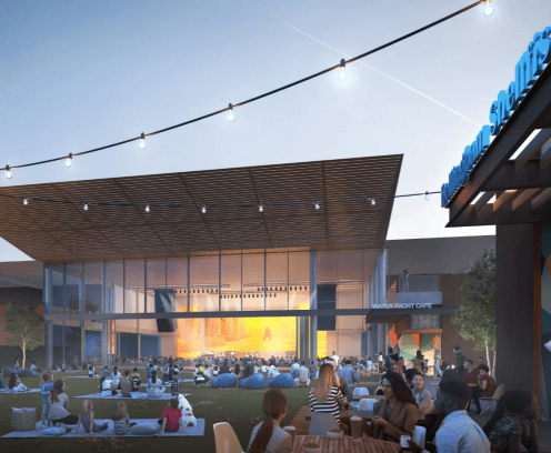 people sitting outside on lawn at an amphitheater