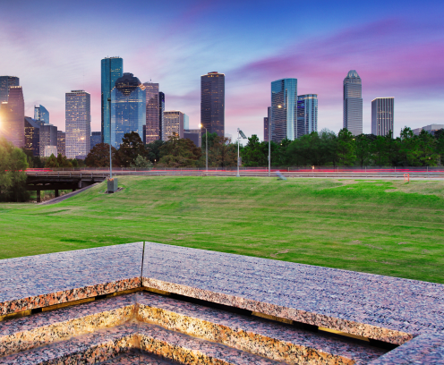 Downtown Houston from Police Memorial park at dramatic sunset. Green park lawn and modern skylines. The most populous city in Texas, and fourth-most in United States.