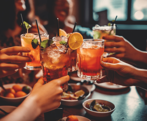 People gathered around a table full of food, toasting their drinks
