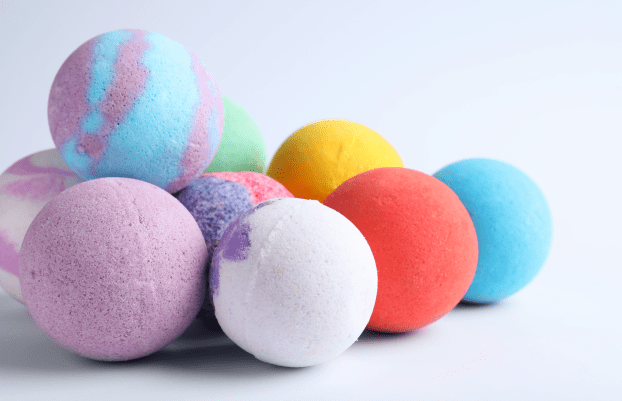 Pile of colorful bath bombs on white background, closeup