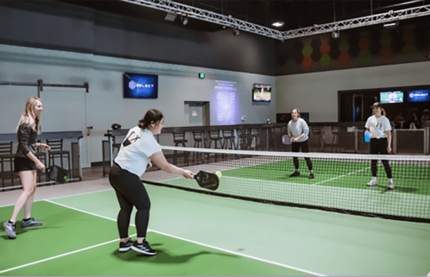Four women playing pickleball.