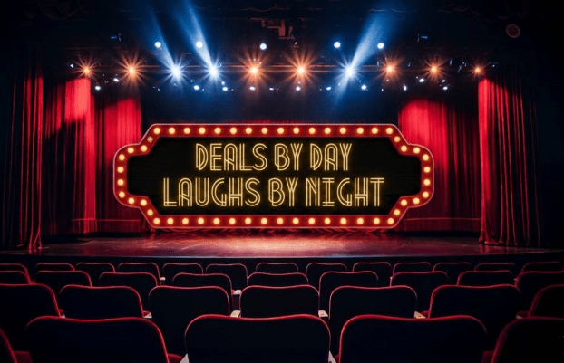 Theatre sign with lights says deals by day, laughs by night.