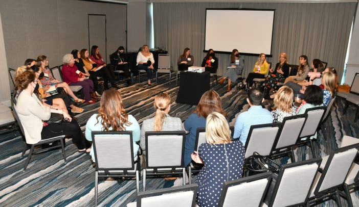 businesspeople seated in a circle at a CREW summit event