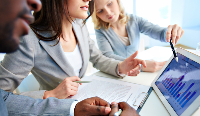 Close-up of young businesswomen discussing document in touchpad
