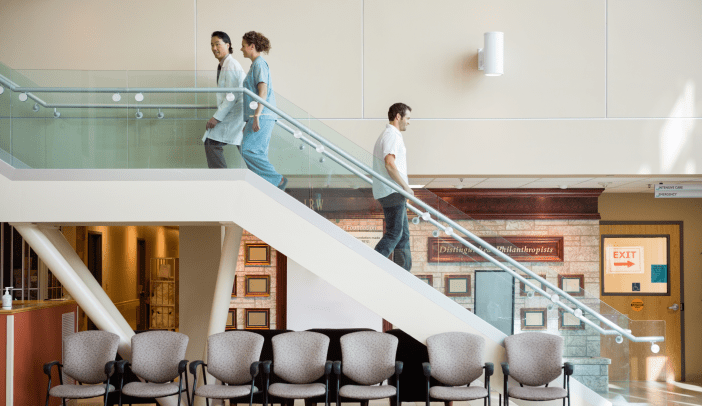 Side view of medical team and man using staircase in hospital