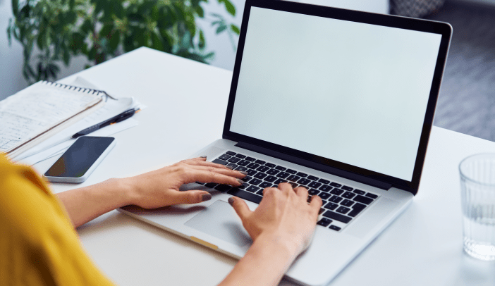 Closeup of woman using laptop with white blank screen mockup