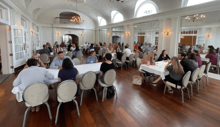 banquet room full of people at tables talking and making connections
