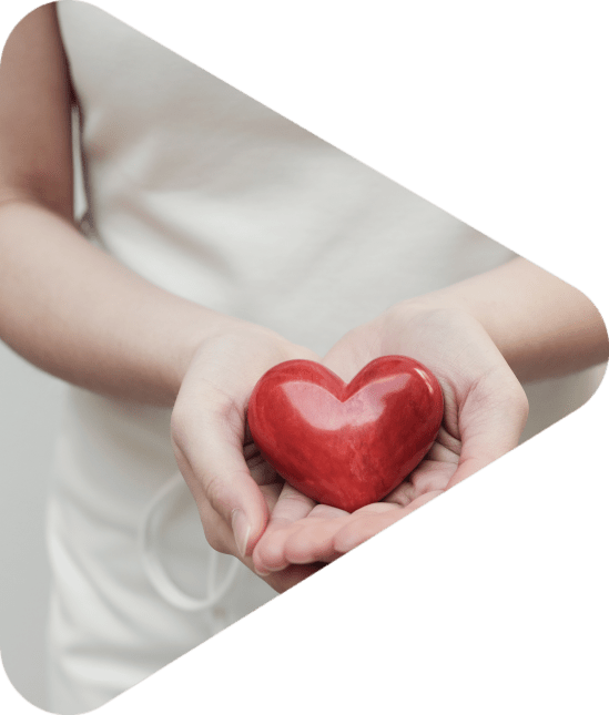 woman offering a red heart-shaped stone to camera