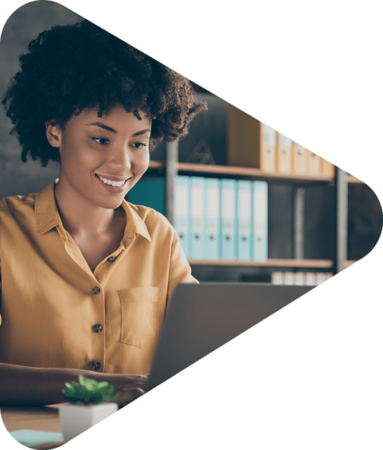 Photo of cheerful positive, mixed-race girl smiling toothily working on laptop