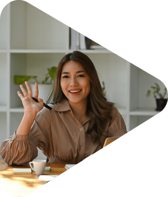 A portrait of a pretty smiley Asian woman sitting in the office looking away and waving hands to colleagues, for business and technology concept.