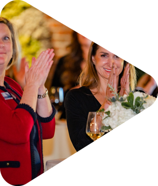 Women standing at a table clapping