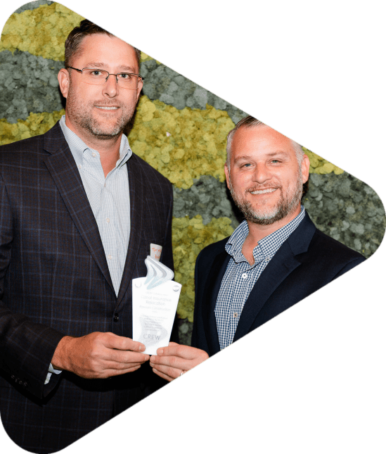 Two men holding an award trophy