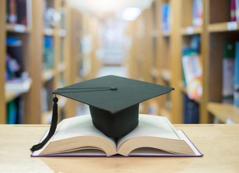graduation cap over open Books on Library room,Education concept
