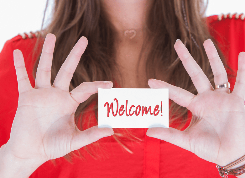 Woman in red showing a business card, welcome