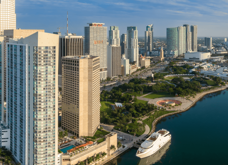 Downtown city skyline and calm ocean waterfront and Bayfront Park of Miami at sunrise, Florida, United States.