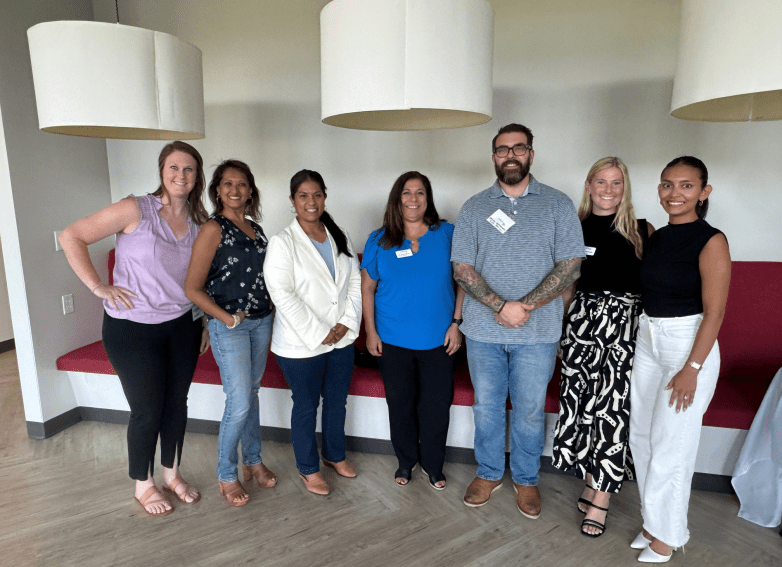 Members standing in front of a wall couch