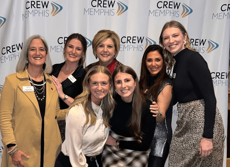 Members posing in front of a CREW Memphis backdrop