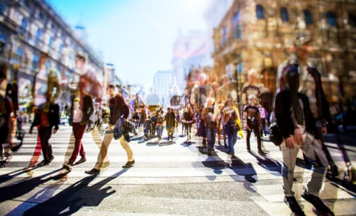 Blurred photo of a crowd of people walking on a busy city street